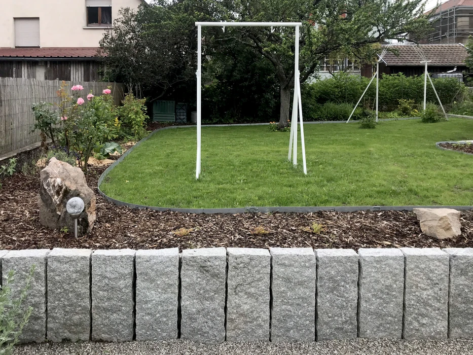 Jardin résidentiel en automne avec petit arbre ou arbuste protégé par une housse de protection hivernale beige nouée à la base